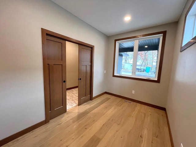 unfurnished bedroom featuring light wood-type flooring and a closet