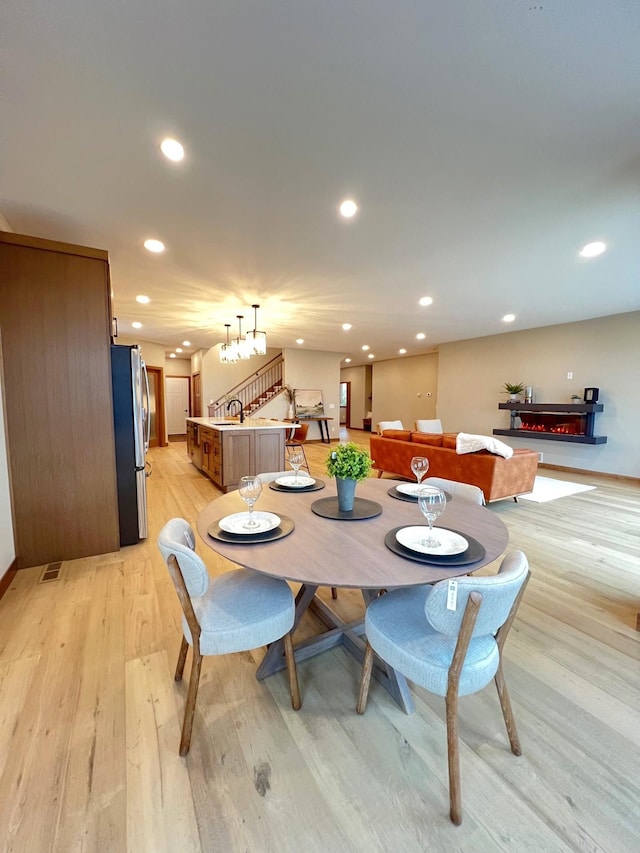 dining room featuring sink and light hardwood / wood-style floors