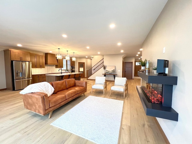 living room with a multi sided fireplace and light wood-type flooring