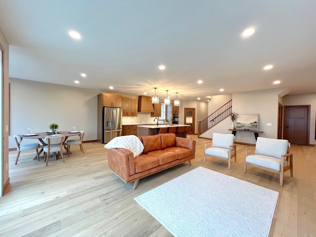 living room featuring sink and light hardwood / wood-style flooring