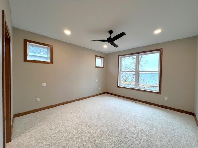 carpeted spare room with ceiling fan