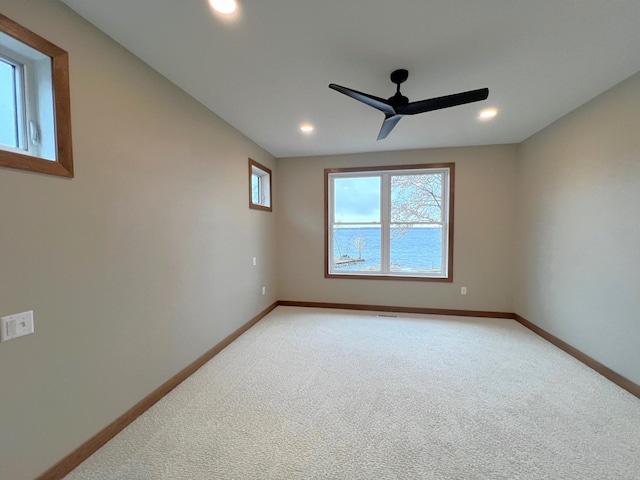 carpeted empty room featuring a wealth of natural light and ceiling fan