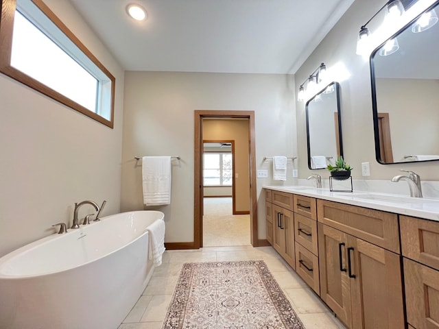 bathroom with vanity, a washtub, and tile patterned floors