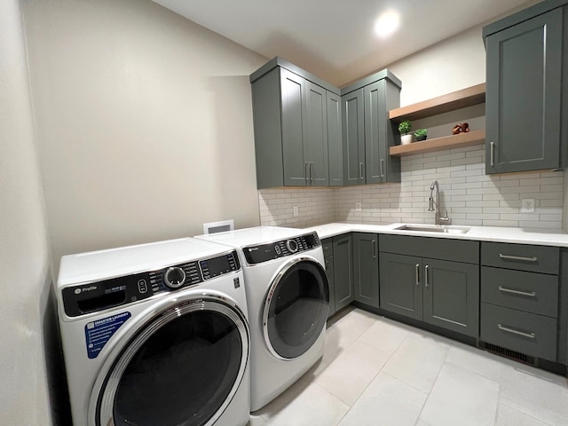 washroom with cabinets, sink, washer and dryer, and light tile patterned floors