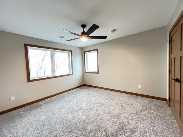 spare room with ceiling fan and carpet