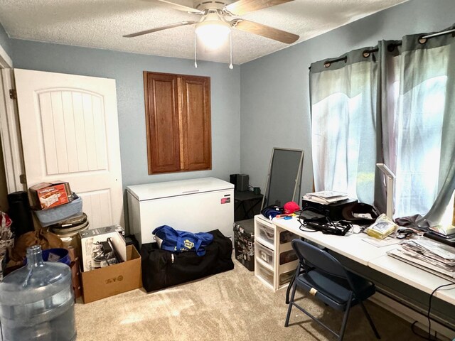 office space featuring ceiling fan, light colored carpet, and a textured ceiling