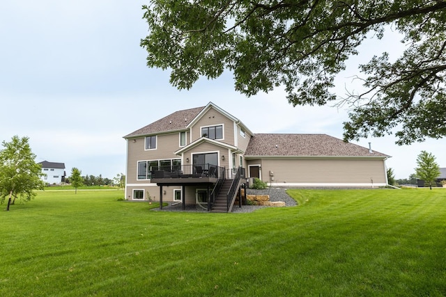 rear view of property with a wooden deck and a lawn