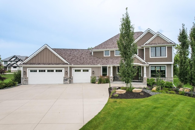 craftsman inspired home with a garage and a front yard