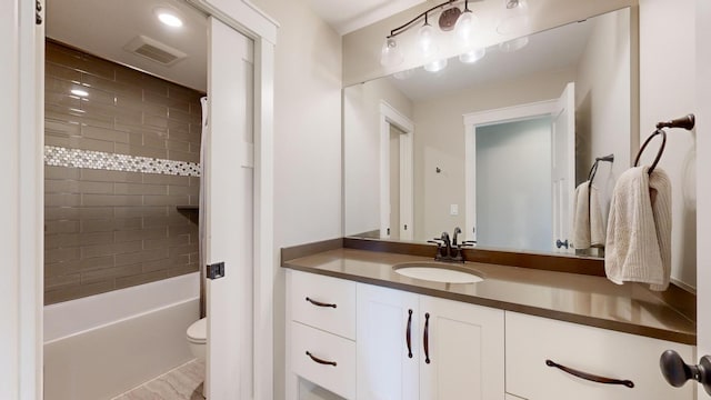 full bathroom with vanity, tiled shower / bath combo, and toilet