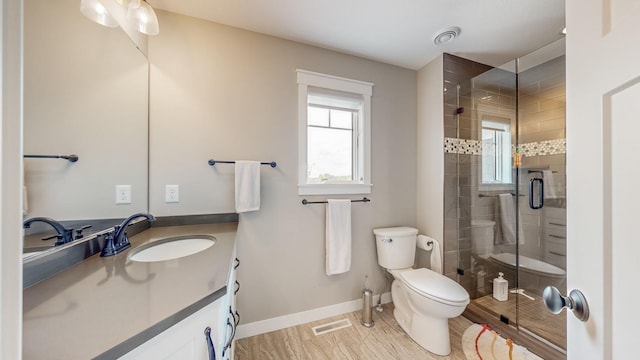 bathroom featuring vanity, an enclosed shower, and toilet