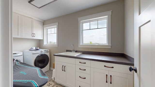 laundry room featuring cabinets, washer and clothes dryer, and sink