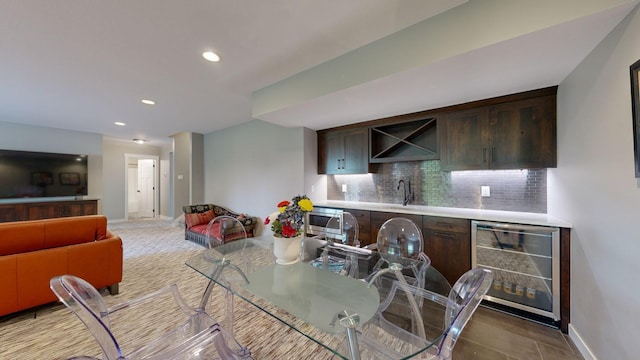 dining space with sink, light tile patterned floors, and beverage cooler