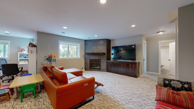 carpeted living room with a tile fireplace