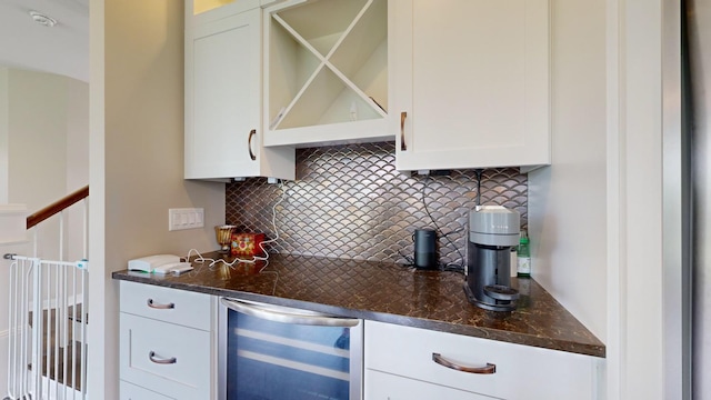 bar with tasteful backsplash, dark stone countertops, beverage cooler, and white cabinets