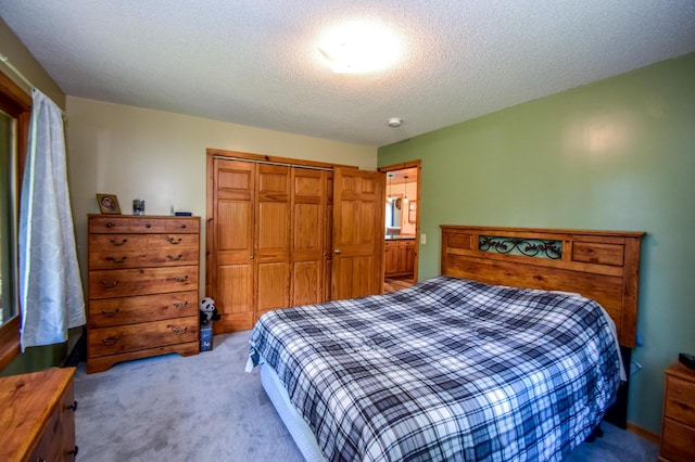 carpeted bedroom featuring a closet and a textured ceiling