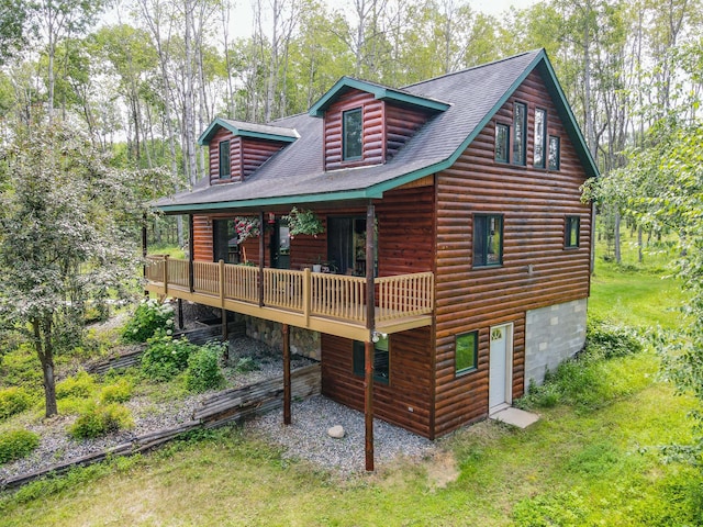 back of property featuring a deck and a lawn