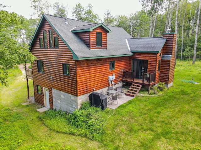 rear view of property featuring a yard, a patio, and a deck