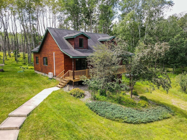 cabin with a wooden deck and a front yard