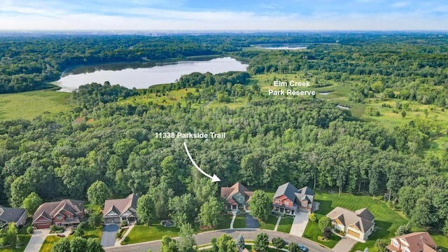 aerial view with a wooded view and a water view