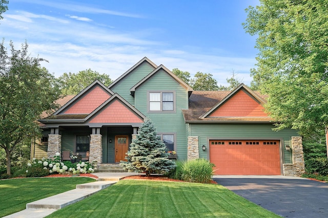 craftsman inspired home featuring aphalt driveway, stone siding, an attached garage, and a front yard