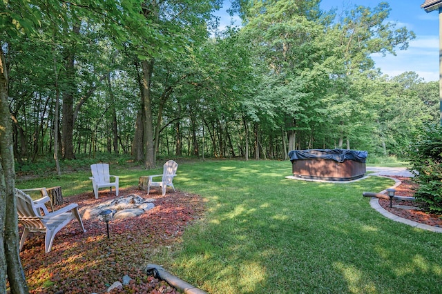 view of yard featuring a pool and an outdoor fire pit