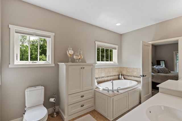 ensuite bathroom featuring tile patterned flooring, toilet, a garden tub, ensuite bathroom, and a sink