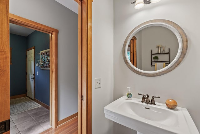 bathroom with a sink, baseboards, and tile patterned floors