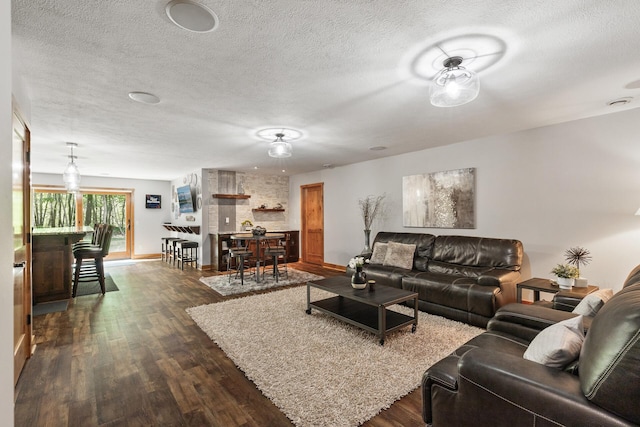 living area with baseboards, a textured ceiling, and dark wood-style flooring