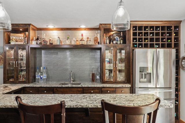 bar featuring decorative backsplash, a sink, recessed lighting, stainless steel fridge, and indoor wet bar