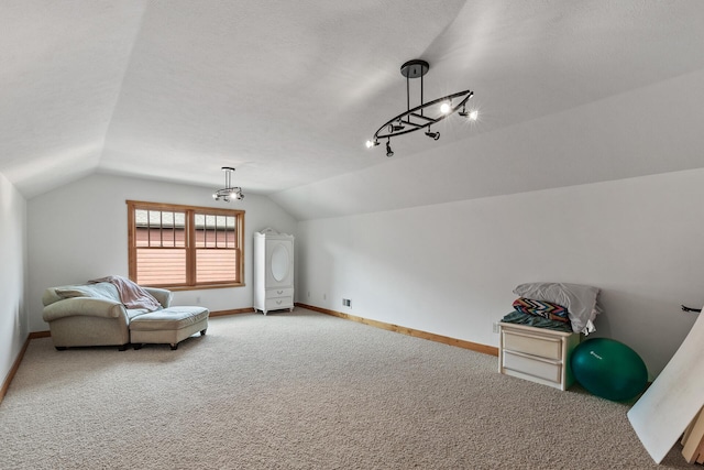 interior space featuring carpet floors, a textured ceiling, baseboards, and vaulted ceiling