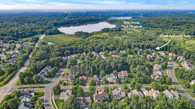 aerial view featuring a residential view, a water view, and a view of trees