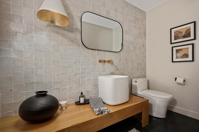 bathroom with tile patterned floors, tile walls, and toilet