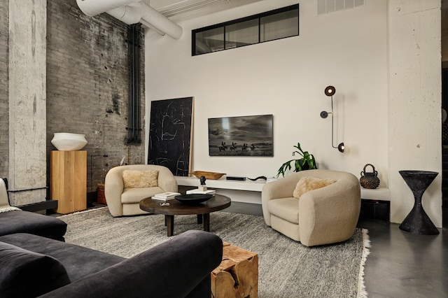 living room featuring concrete floors and a high ceiling