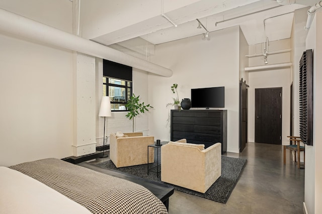 bedroom with concrete floors and a high ceiling