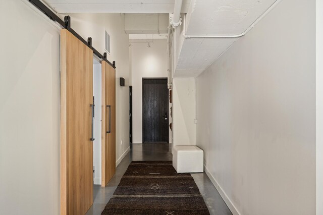 hall featuring a barn door and a high ceiling