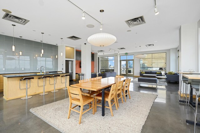 dining room with rail lighting, french doors, and sink