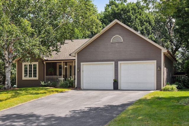 ranch-style home featuring a porch, a garage, and a front yard