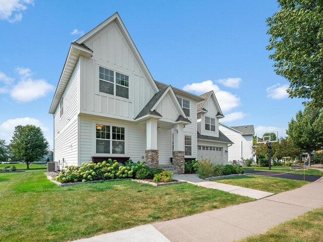 view of front of home featuring central AC, a front lawn, and a garage