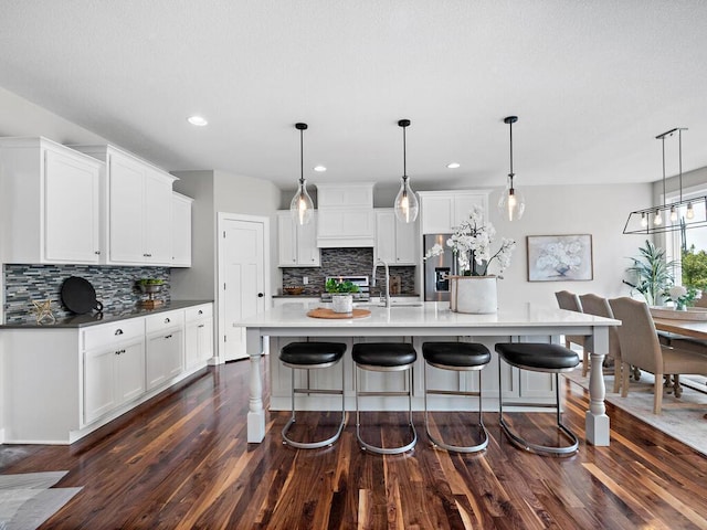 kitchen with pendant lighting, white cabinetry, and a spacious island