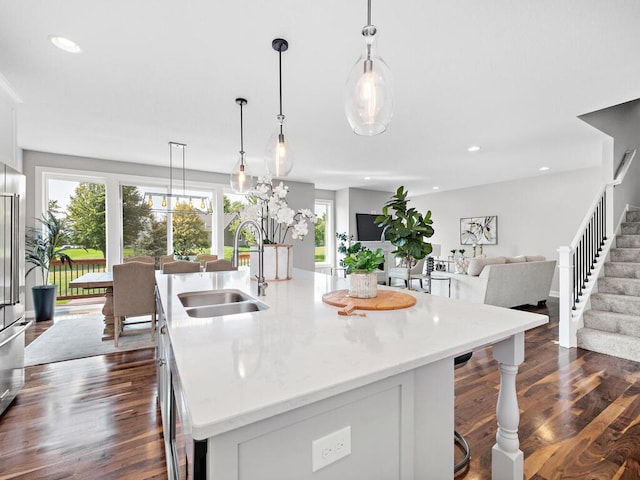 kitchen with pendant lighting, plenty of natural light, sink, and a kitchen island with sink