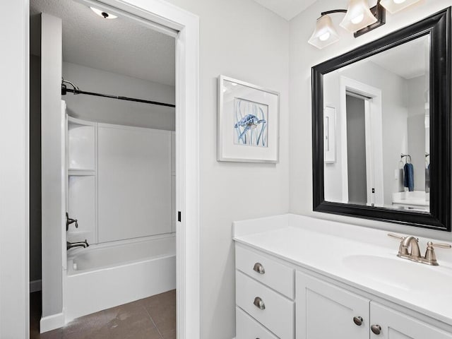 bathroom with tile patterned floors, vanity, washtub / shower combination, and a textured ceiling