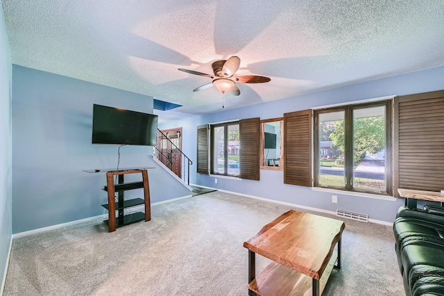 carpeted living room featuring a textured ceiling and ceiling fan