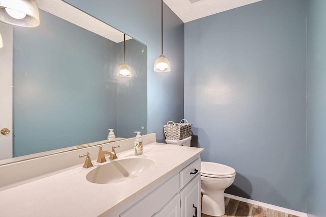 bathroom featuring wood-type flooring, vanity, and toilet