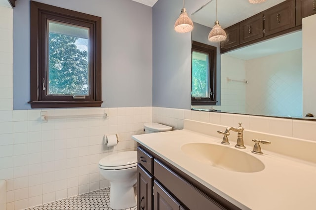 bathroom with a healthy amount of sunlight, tile patterned flooring, vanity, and toilet