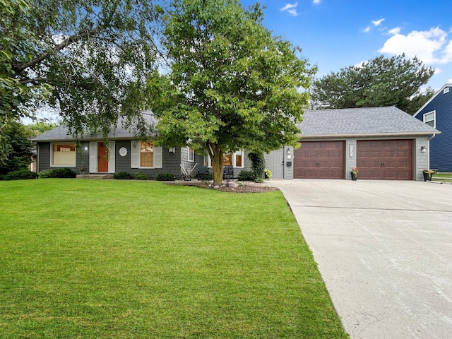 view of front of house featuring a garage, a front yard, concrete driveway, and a shingled roof