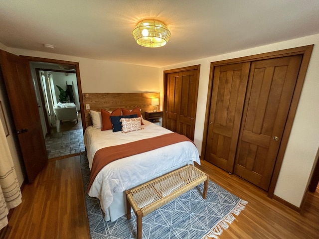 bedroom featuring hardwood / wood-style floors and multiple closets