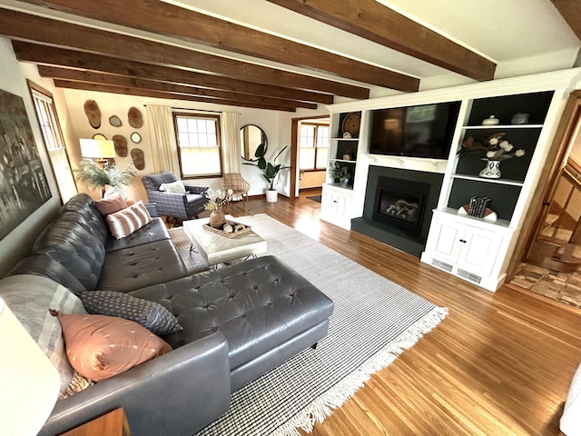 1324 Ridgeview Dr, Montevideo, MN 56265 - living area featuring a fireplace with raised hearth, beamed ceiling, and wood finished floors