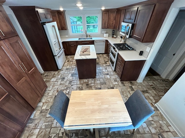 1324 Ridgeview Dr, Montevideo, MN 56265 - kitchen featuring a center island, high end appliances, light countertops, a sink, and dark brown cabinets