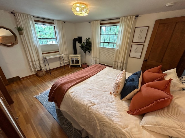 1324 Ridgeview Dr, Montevideo, MN 56265 - bedroom with a wood stove, baseboards, and wood finished floors