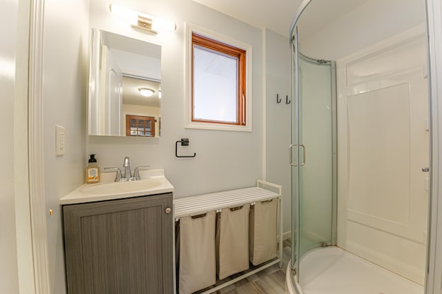 bathroom featuring an enclosed shower, wood-type flooring, and vanity